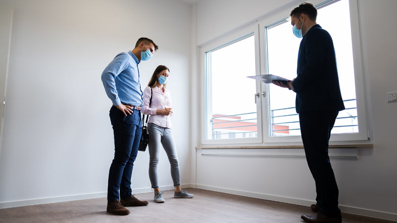 mediador imobiliário a mostrar imóvel a casal